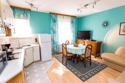 a kitchen and living room with a table and chairs at Apartments Dinka Vantačići in Malinska