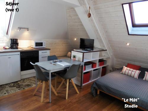 una pequeña cocina con una mesa y una cama en una habitación en Résidence La Hoguette en Saint-Malo