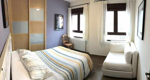 a bedroom with a bed and a chair in it at Casa Rural El Batán Casa rural 37 personas in Toledo