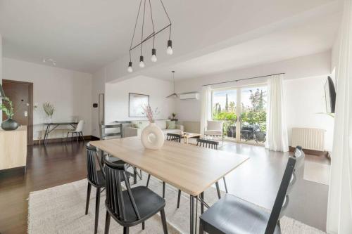 a dining room and living room with a table and chairs at Panoramic 1BR Apartment near Kallimarmaro Stadium by UPSTREET in Athens