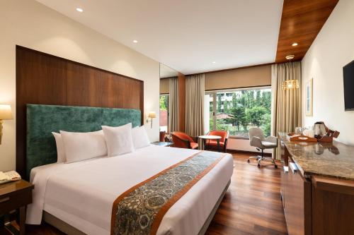 a hotel room with a bed and a desk at Welcomhotel by ITC Hotels, Devee Grand Bay, Visakhapatnam in Visakhapatnam