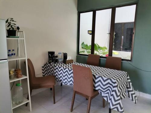 ein Esszimmer mit einem Tisch, Stühlen und einem Fenster in der Unterkunft Eng Ban Hin guesthouse in Malakka