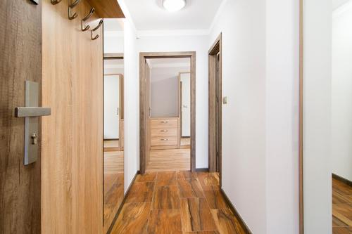 a hallway with white walls and a wooden floor at Małe Tęczowe Wzgórze in Wisła