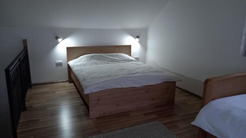 Habitación pequeña con 2 camas y suelo de madera. en Zlatna Jabuka apartman en Prijepolje