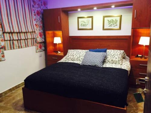 a bedroom with a large bed with two lamps on the wall at The Royal Luxury Tiger Patio in Amman