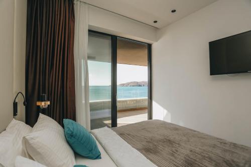 a bedroom with a bed with a view of the ocean at Beachfront luxury apartment in Budva