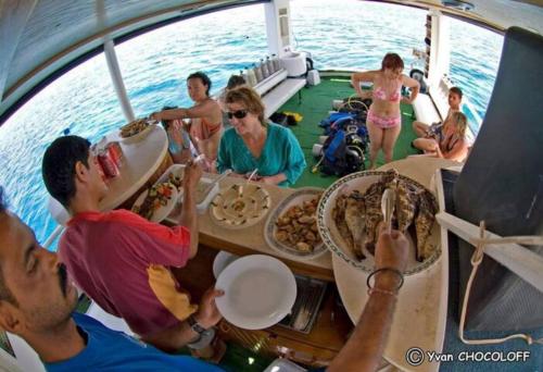 un grupo de personas sentadas alrededor de una mesa en un barco en The Royal Luxury Tiger Patio en Amán