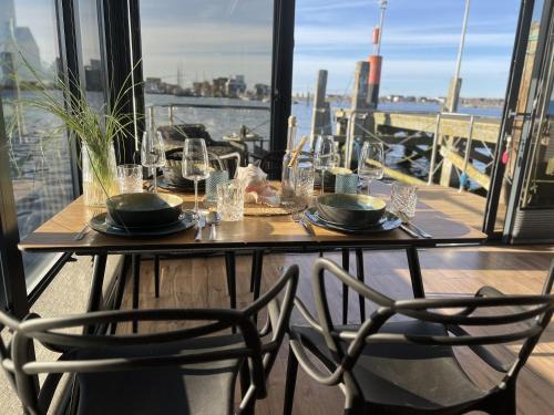 a table on a balcony with a view of the city at Hausboot mit Motorboot in Heiligenhafen