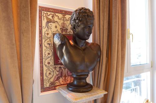 a statue of a man on a stand next to a window at Royal Olympus Verona in Verona