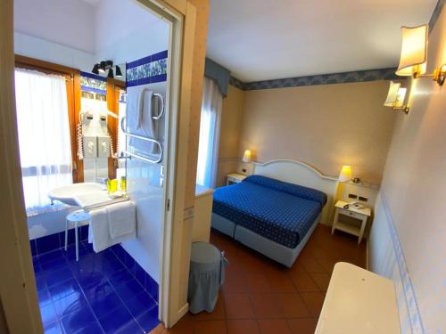 a small room with a bed and a bathroom at Il Ghebo in Cavallino-Treporti