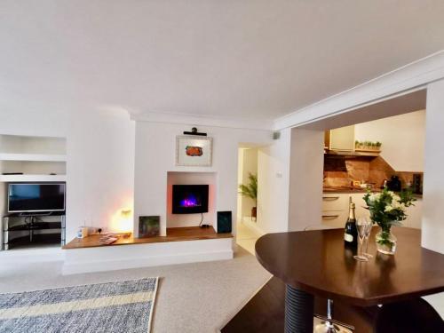 a living room with a table and a fireplace at Sandsifter at 4 Trencrom Court, Carbis Bay,St Ives, Cornwall in Carbis Bay