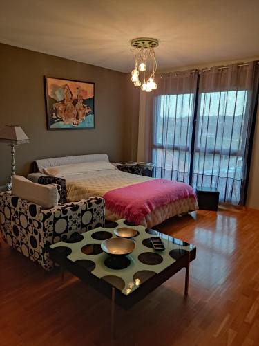 a bedroom with a bed and a coffee table at Acogedor apartamento en Noreña in Noreña