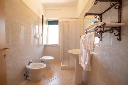 a bathroom with a toilet and a bidet and a sink at Residence L'Africhetta in Rodi Garganico