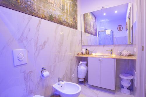 a bathroom with a sink and a toilet and a mirror at Royal Olympus Verona in Verona