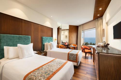 a hotel room with two beds and a television at Welcomhotel by ITC Hotels, Devee Grand Bay, Visakhapatnam in Visakhapatnam