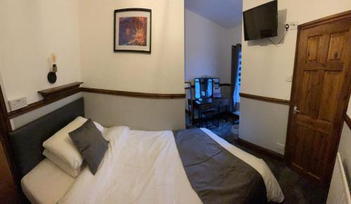 een slaapkamer met een bed en een televisie. bij Rendezvous Bar & Rooms - ADULTS ONLY in Blackpool
