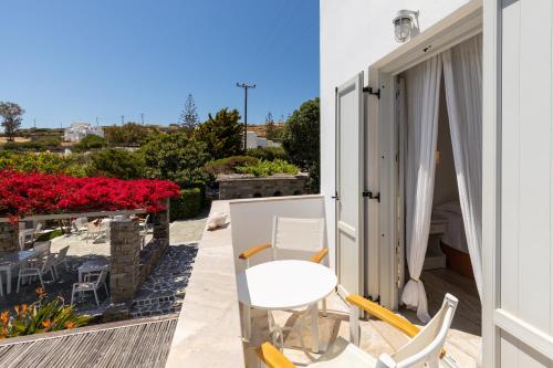 a patio with a white table and chairs on a balcony at Roses Beach in Parikia