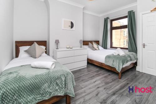a bedroom with two beds and a window at Host Liverpool - Spacious family home pets welcome in Liverpool