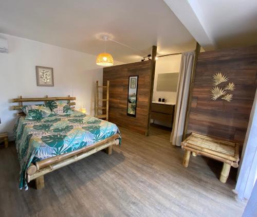 a bedroom with a bed and a bench in it at Ti bambou nature in Sainte-Anne