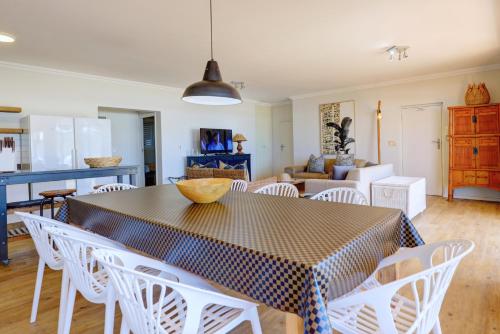 a dining room and living room with a table and chairs at Oppiesee Selfcatering Apartments in Herolds Bay