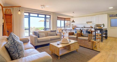 a large living room with couches and a table at Oppiesee Selfcatering Apartments in Herolds Bay