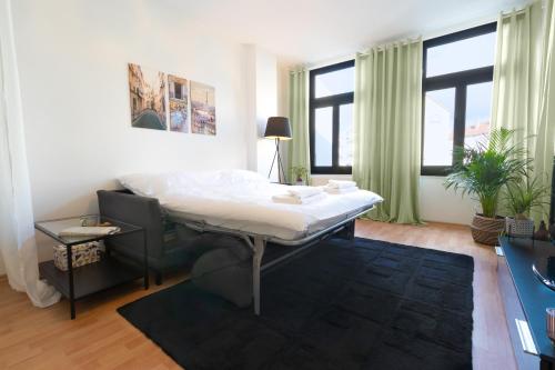 a white bed in a room with windows at Ruhige Wohnung in zentraler Lage - Quiet flat in a central location in Magdeburg