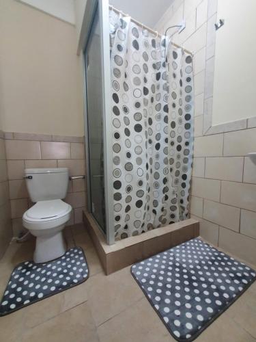 ein Badezimmer mit Dusche mit Toilette und Duschvorhang in der Unterkunft Lovely 2 Bedroom Apartment with shared pool in Roseau