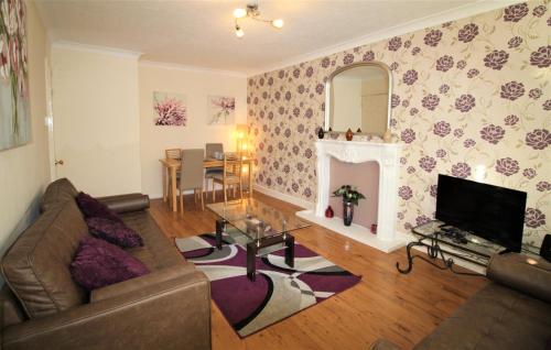 a living room with a couch and a fireplace at Large Balcony Apartment - 2 Double Beds - Sleeps 4 - Close to Town & Racecourse - Off Street Parking 2 Cars - Fast Wifi in Doncaster