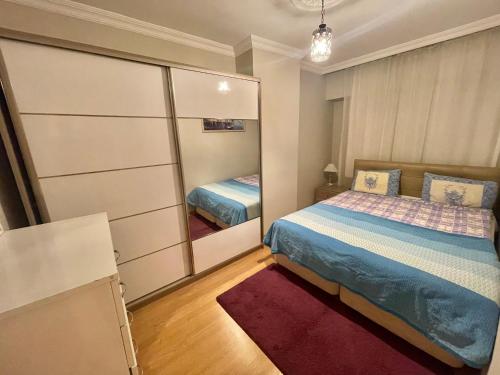 a small bedroom with a bed and a mirror at Ucal Apart in Istanbul