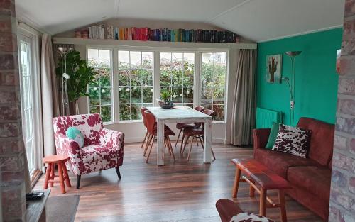 a living room with a table and chairs at dutchduochalet13 in s-Gravenzande