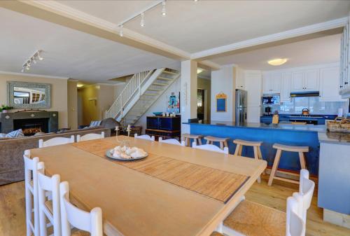 a dining room and kitchen with a table and chairs at Oppiesee Selfcatering Apartments in Herolds Bay