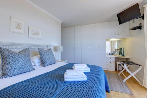 a bedroom with a blue bed with towels on it at Oppiesee Selfcatering Apartments in Herolds Bay