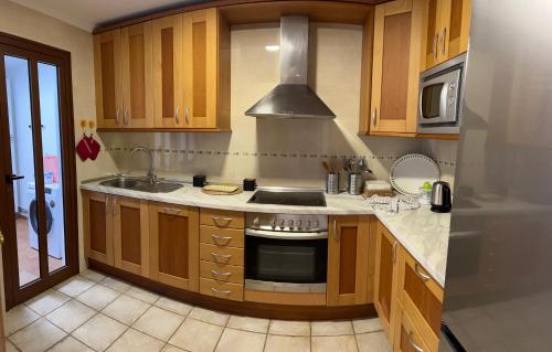 cocina con fregadero y fogones horno superior en Villa linda, en Playa Blanca