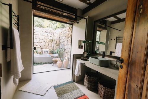 a bathroom with a tub and a sink and a mirror at Casa Salga in Ilhabela