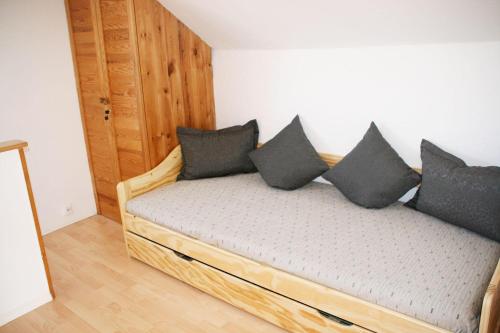 ein Schlafzimmer mit einem Bett mit schwarzen Kissen darauf in der Unterkunft Ferienhaus Kassiopeia in Laboe