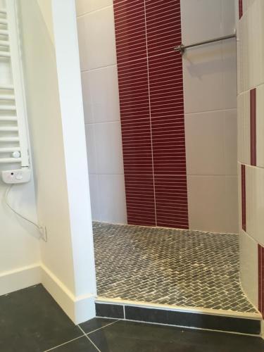 łazienka z prysznicem z czerwonymi drzwiami w obiekcie L'Aubergiste w mieście Corcelles-les-Arts