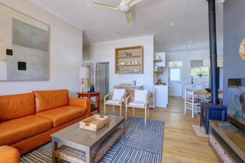 a living room with a couch and a table at Oppiesee Selfcatering Apartments in Herolds Bay