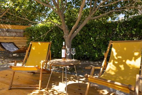 two chairs and a table with a bottle of wine at Roses Beach in Parikia