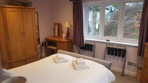 a room with a bed with two towels on it at Beech Apartment in Bowness-on-Windermere
