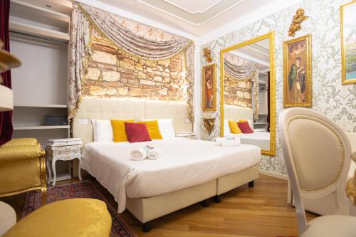 a bedroom with two beds and a mirror at Royal Giardini dell'Arena Relais - Royal Welcome in Verona