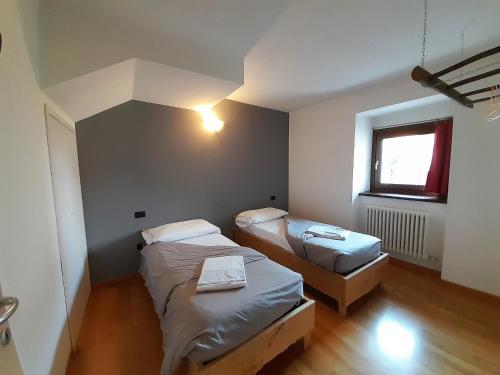 una camera con due letti e una finestra di IL RUSTICO appartamento vacanze a Tresivio