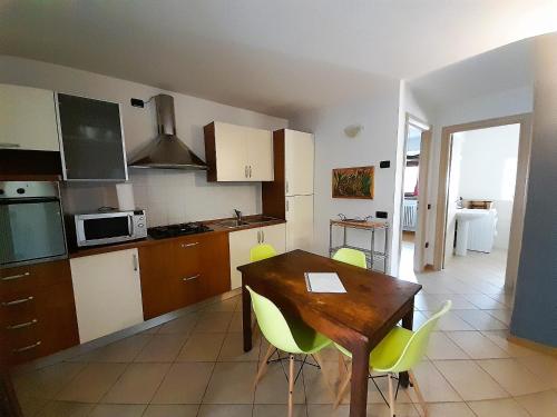 eine Küche mit einem Holztisch und gelben Stühlen in der Unterkunft IL RUSTICO appartamento vacanze in Tresivio