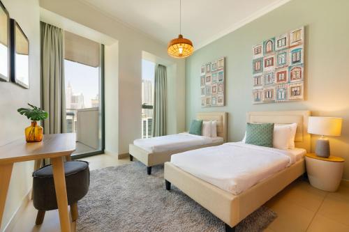a bedroom with two beds and a desk and a table at Maison Privee - 5 Stars Apt in Architectural Marvel of Dubai in Dubai