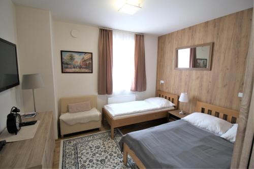 a hotel room with two beds and a television at Apartmany Rezidence Klostermann & Javor & Skalka in Železná Ruda
