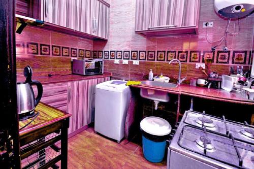 a pink kitchen with a sink and a refrigerator at Appartment down town in Cairo