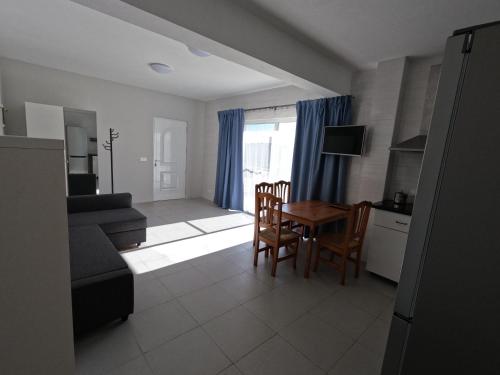 a kitchen and living room with a table and chairs at Apartamentos Praia do Almoxarife in Horta
