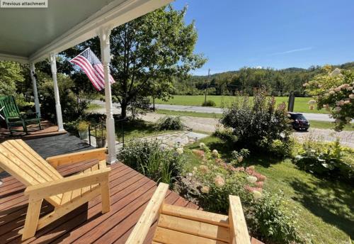 a wooden deck with a bench and an american flag at Stone Hearth Inn and Eatery in Chester