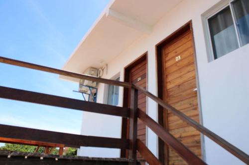 a staircase leading up to a house with a wooden door at Encanto da Praia hotel pousada in Natal