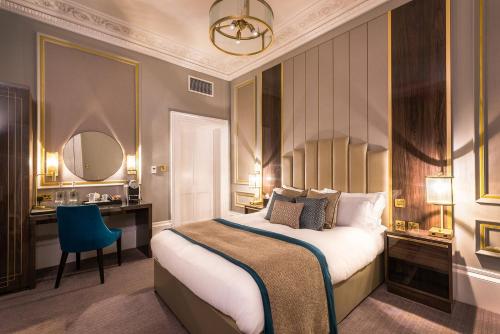 a bedroom with a large bed and a blue chair at Edgbaston House in Birmingham