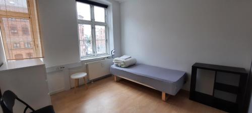 Habitación pequeña con cama y TV. en Private Room in a shared apartment, en Odense